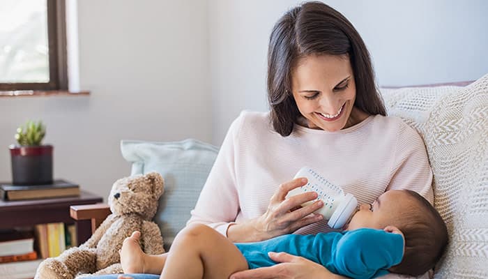 mother holding baby milk bottle